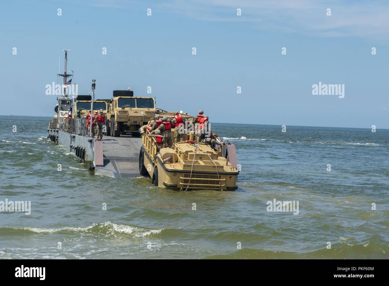 VIRGINIA BEACH, Va. (26 luglio 2018) marinai provenienti da unità Beachmaster (BMU) 2 Usare un accendisigari, rifornimento anfibio, Cargo, cinque - ton (LARC - V) a scendere U.S. I driver dell'esercito su un Marina migliorato sistema di alleggio (INLS) Causeway Ferry azionato da costruzione anfibio battaglione (ACB) 2 durante il Tridente Sun 18 esercizio congiunto di bordo Base Expeditionary Little Creek - Fort Story. Trident Sun 18 è un preposizionamento marittima forza (MPF) operazione destinata a fornire una formazione alla componente di riserva personale per quanto riguarda il flusso in offload di veicoli e attrezzature militari. Foto Stock