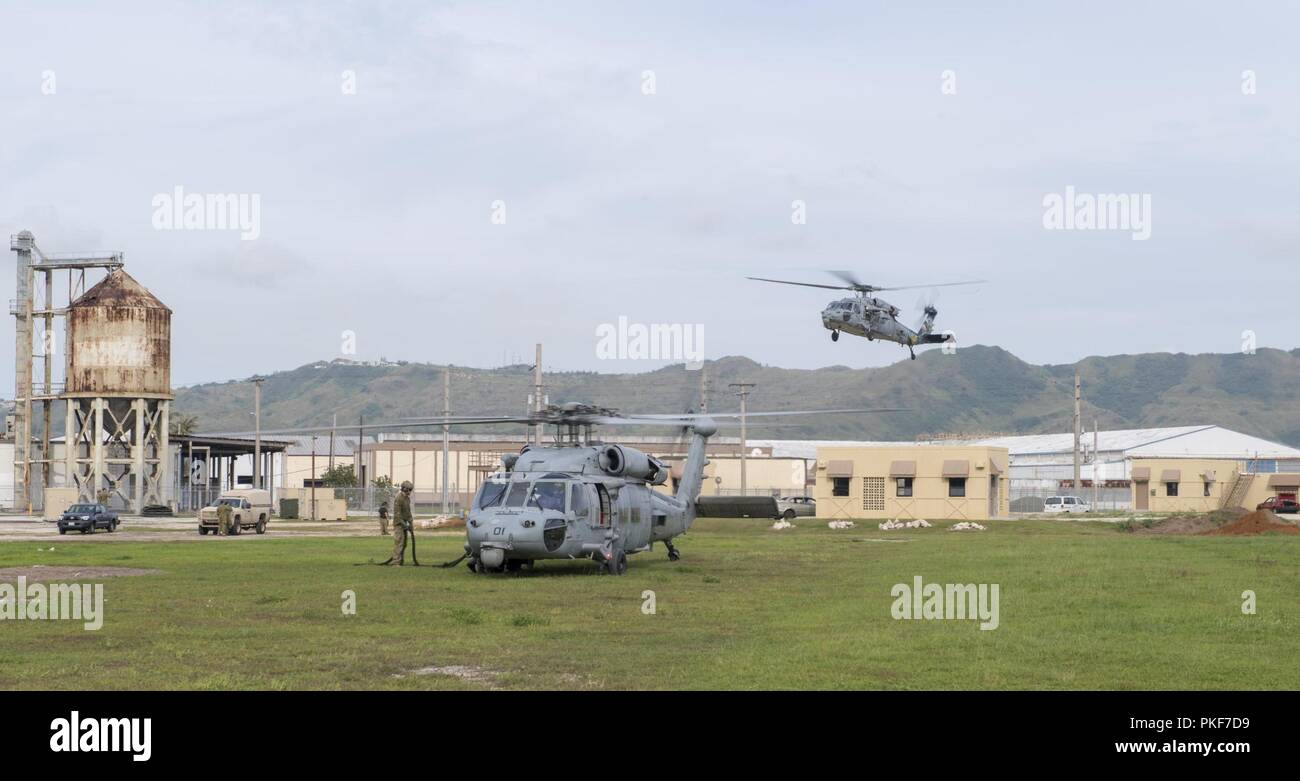 I marinai fissato per l'eliminazione degli ordigni esplosivi unità mobile (EODMU) 5 e l'Esercito Australiano soldati preparare alla corda veloce da MH-60S elicotteri da elicottero mare squadrone di combattimento (HSC) 25, l'isola di cavalieri, durante l'unità di formazione di livello "Pyrocrab' alla base navale di Guam, 8 agosto 2018. Pyrocrab è una biennale Livello unità di formazione che si concentra sul rafforzamento delle relazioni e migliorando l'interoperabilità tra gli Stati Uniti La marina e le forze di australiano. EODMU-5 è assegnato al comandante, Task Force 75, il primario expeditionary task force responsabile per la pianificazione e la realizzazione di fiume costiera Foto Stock