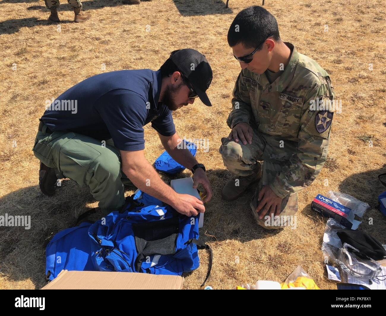 Una tra le agenzie nazionali Centro antincendio gazzetta dimostra la corretta tecnica di imballaggio per i dispositivi di protezione individuale di una brigata xiv ingegnere soldato battaglione durante la fase iniziale di fasi di preparazione per il fire suppression missione il supporto tra le agenzie nazionali Centro antincendio nella soppressione di incendi negli Stati Uniti occidentali, e il Agosto 9, 2018 a base comune Lewis-Mccorda. Foto Stock
