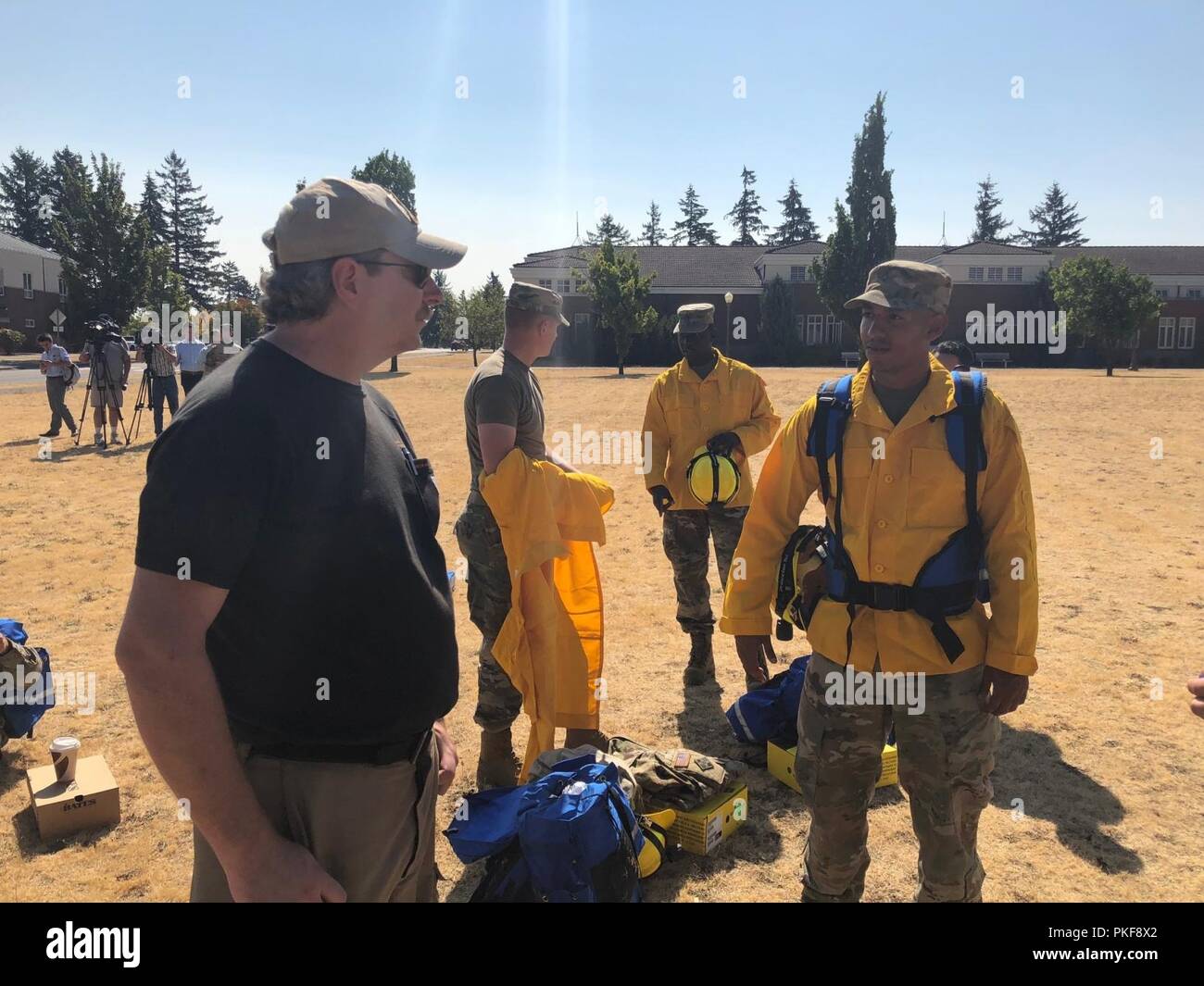 Pfc. Javonte Duran dal XIV Brigata Battaglione ingegnere, 2° Stryker Brigade Combat Team, chiede una tra le agenzie nazionali Fire centro ufficiale di circa il corretto uso dei dispositivi di protezione per il fire suppression missione il supporto tra le agenzie nazionali Centro antincendio nella soppressione di incendi negli Stati Uniti occidentali, e il Agosto 9, 2018 a base comune Lewis-Mccorda. Foto Stock