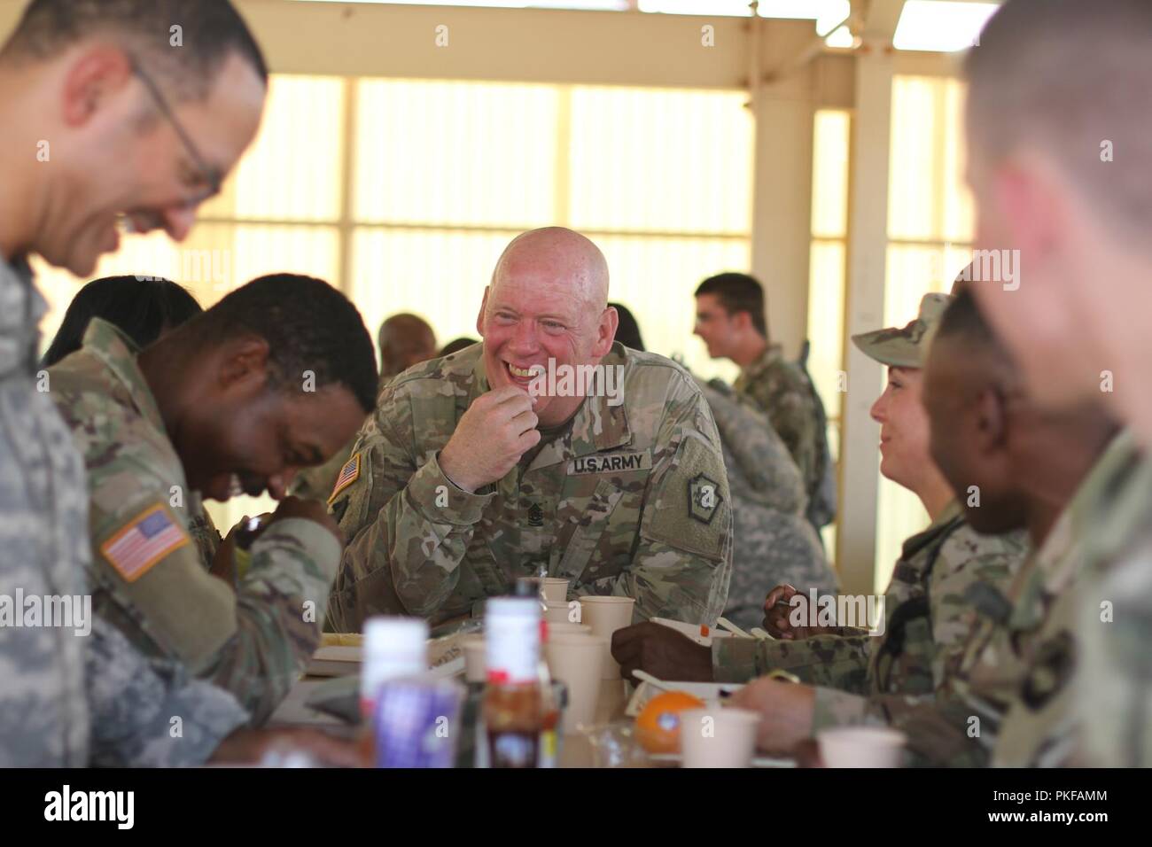 Il comando Sgt. Il Mag. Harry J. Buchanan, senior advisor arruolato in Pennsylvania di aiutante generale, gode la cena chow con soldati provenienti da 213o regionale gruppo di supporto, Pennsylvania National Guard 10 Agosto presso il Centro Nazionale di Allenamento, Fort Irwin, California Truppe dal 213o RSG sostenere la cinquantaseiesima Stryker Brigade Combat Team, ventottesima divisione di fanteria durante la rotazione di formazione a NTC. Foto Stock