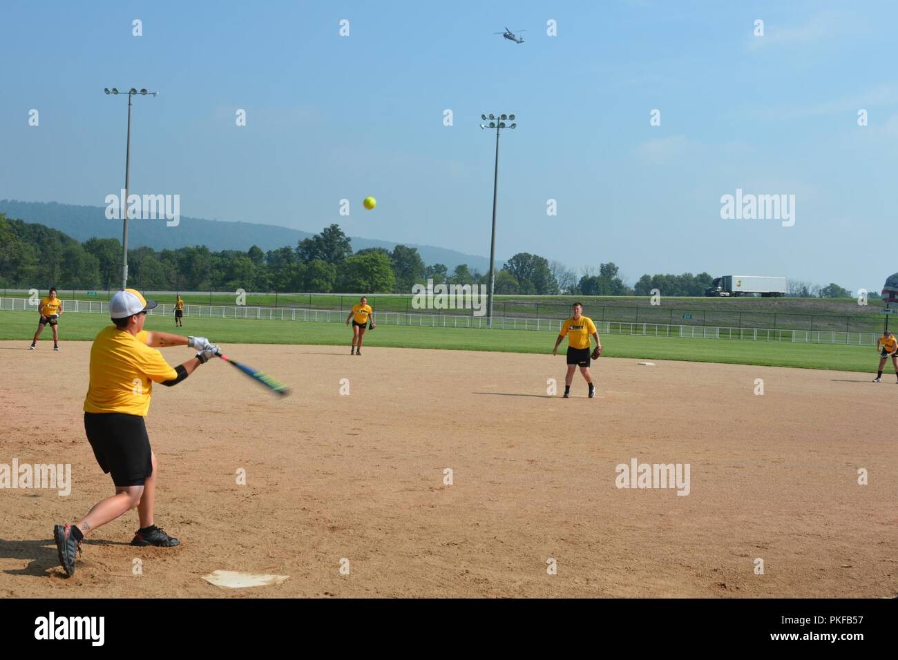 Sgt. Teresa aringa, di stanza a base comune Lewis-Mccorda, Washington va a bat come UH-60 Black Hawk flies overhead, durante le libere 7 Agosto a Fort Indiantown Gap, Pa. l esercito tutte le donne di Softball team hanno tenuto la loro xli camp questo anno presso l'installazione. Foto Stock