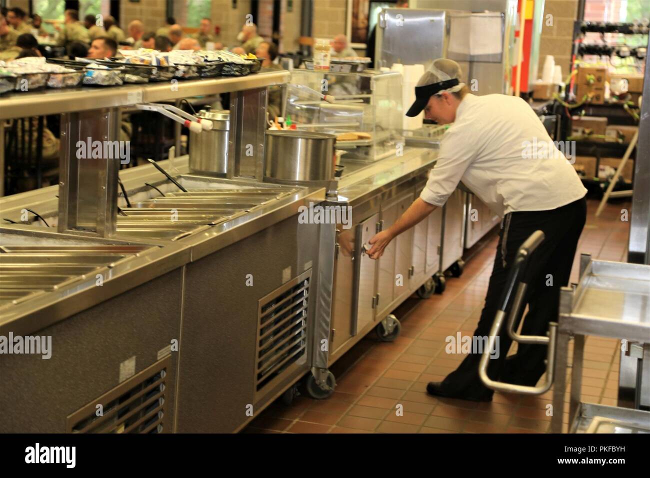 Un dipendente con l'appaltatore DCT Inc. lavora nell'impianto da pranzo nell'Edificio 50 su 3 Agosto 2018, a Fort McCoy, Wis. ogni volta un grande esercizio come una lotta contro la formazione per il supporto di esercizio avviene a Fort McCoy, migliaia di truppe hanno bisogno di essere alimentate. L'installazione del cibo-service team assicura che il bisogno è sempre soddisfatte. Il team che include il cibo Program Management Office e la sussistenza di alimentazione Ufficio di gestione con il Fort McCoy disponibilità logistica centro; il cibo full-service DCT contraente Inc.; e i fornitori di prodotti alimentari quali alimenti Sysco di Baraboo, Wis. Foto Stock