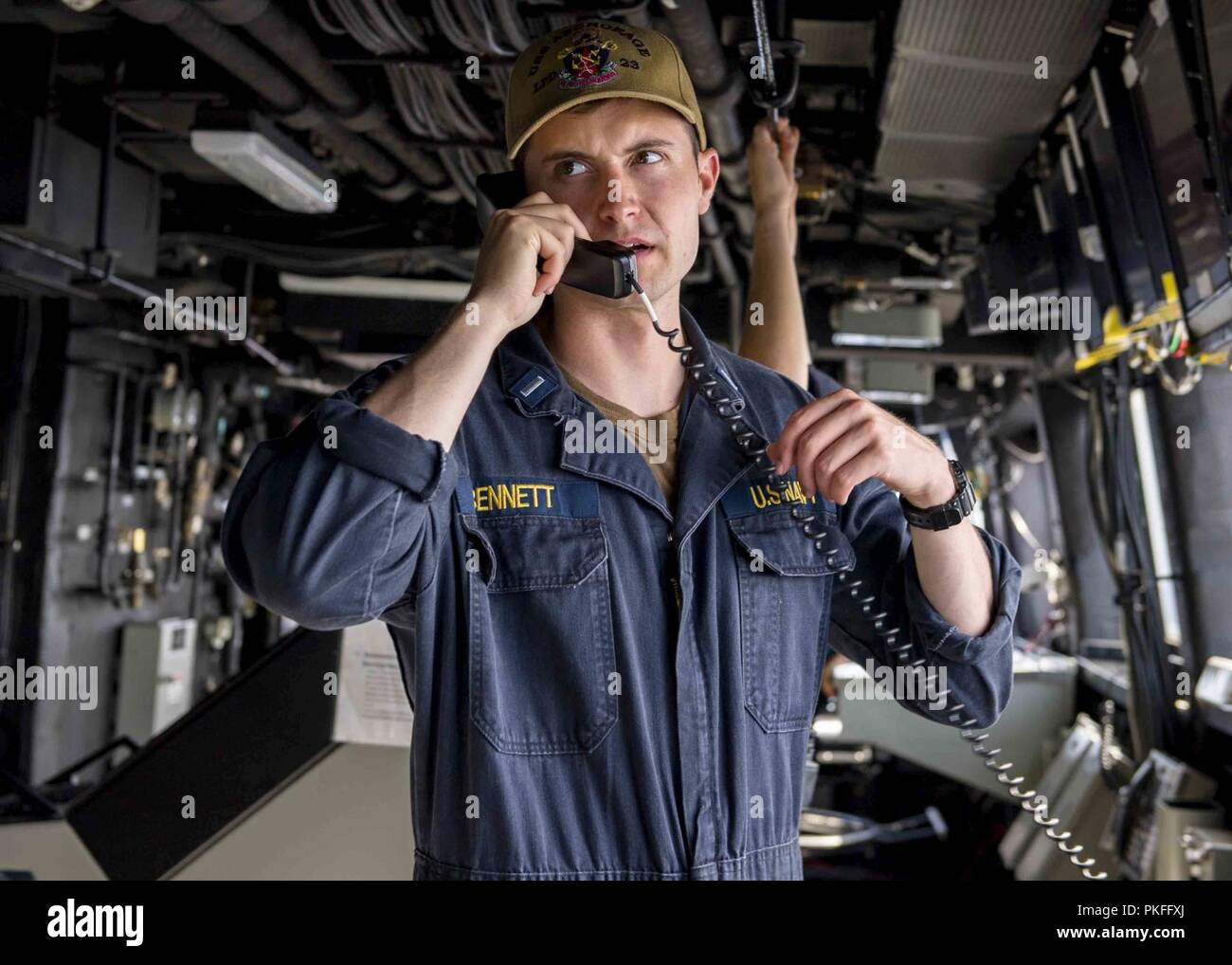 Oceano Pacifico (27 luglio 2018) Il tenente j.g., Nicholas Bennett, da Tampa, Florida, parla al telefono mentre sta in piedi junior officer del ponte guarda al pilota di casa di San Antonio-classe di trasporto anfibio dock USS ancoraggio LPD (23) durante una regolare distribuzione pianificata di Essex anfibio gruppo pronto (ARG) e xiii Marine Expeditionary Unit (MEU). L'Essex ARG/MEU team è un forte e flessibile dotato di forza e scalabili per rispondere a qualsiasi crisi compresa tra aiuti umanitari e di soccorso in caso di catastrofe per le operazioni di emergenza. Foto Stock