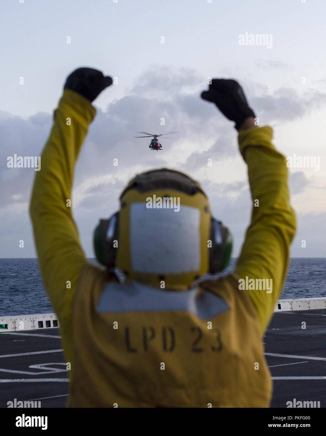 Oceano Pacifico (Luglio 27, 2018) di aviazione di Boatswain Mate (manipolazione) Airman Eddie De La Cruz, da Garden Grove, California, segnali a UH-1Y Venom elicottero, assegnato al Marine Attacco leggero elicottero il distacco del mezzo marino Tiltrotor Squadron (VMM) 166, di atterrare sul ponte di volo di San Antonio-classe di trasporto anfibio dock USS ancoraggio LPD (23) durante una regolare distribuzione pianificata di Essex anfibio gruppo pronto (ARG) e xiii Marine Expeditionary Unit (MEU). L'Essex ARG/MEU team è un forte e flessibile dotato di forza e scalabili per rispondere alle situazioni di crisi che vanno da quelle umanitarie come Foto Stock