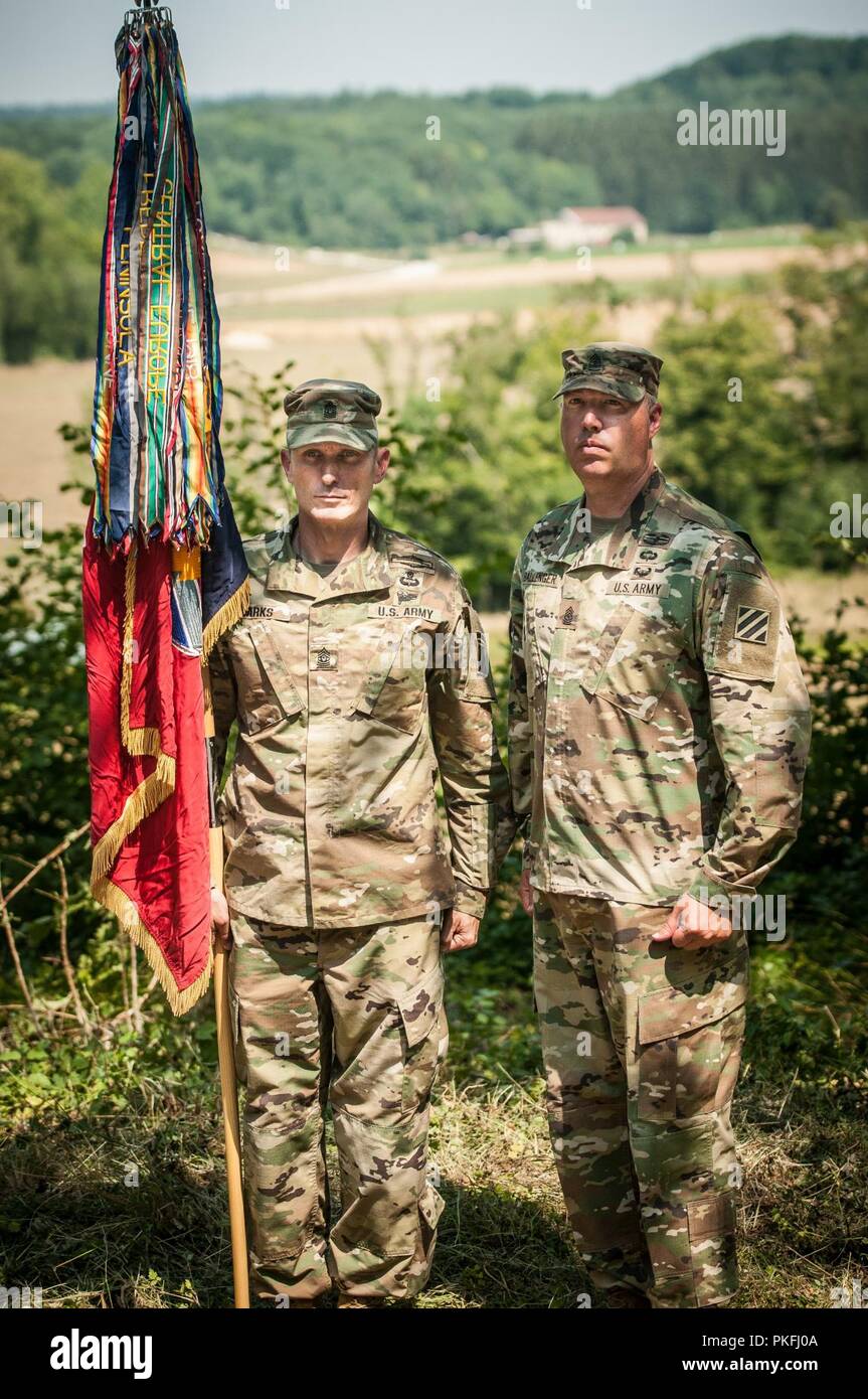 Il comando Sgts. Il Mag. Matteo Marchi (sinistra) e John Ballenger della Georgia esercito nazionale della guardia 48th della brigata di fanteria combattere Team stand con la bandiera dei vigili del fuoco di fronte alla Fattoria Musarde Luglio 25, 2018 vicino a Landres-et-Saint-Georges, Francia. La XLVIII IBCT perpetua la stirpe di società B, 151st Mitragliatrice battaglione, XLII di divisione che ha combattuto qui 15-16 ottobre 1918, durante la campagna di Meuse-Argonne. La Guardia Nazionale i soldati furono in Francia luglio 24-31 come parte dell'U.S. Esercito la I Guerra Mondiale commemorazione centenaria. (Ohio National Guard Foto Stock