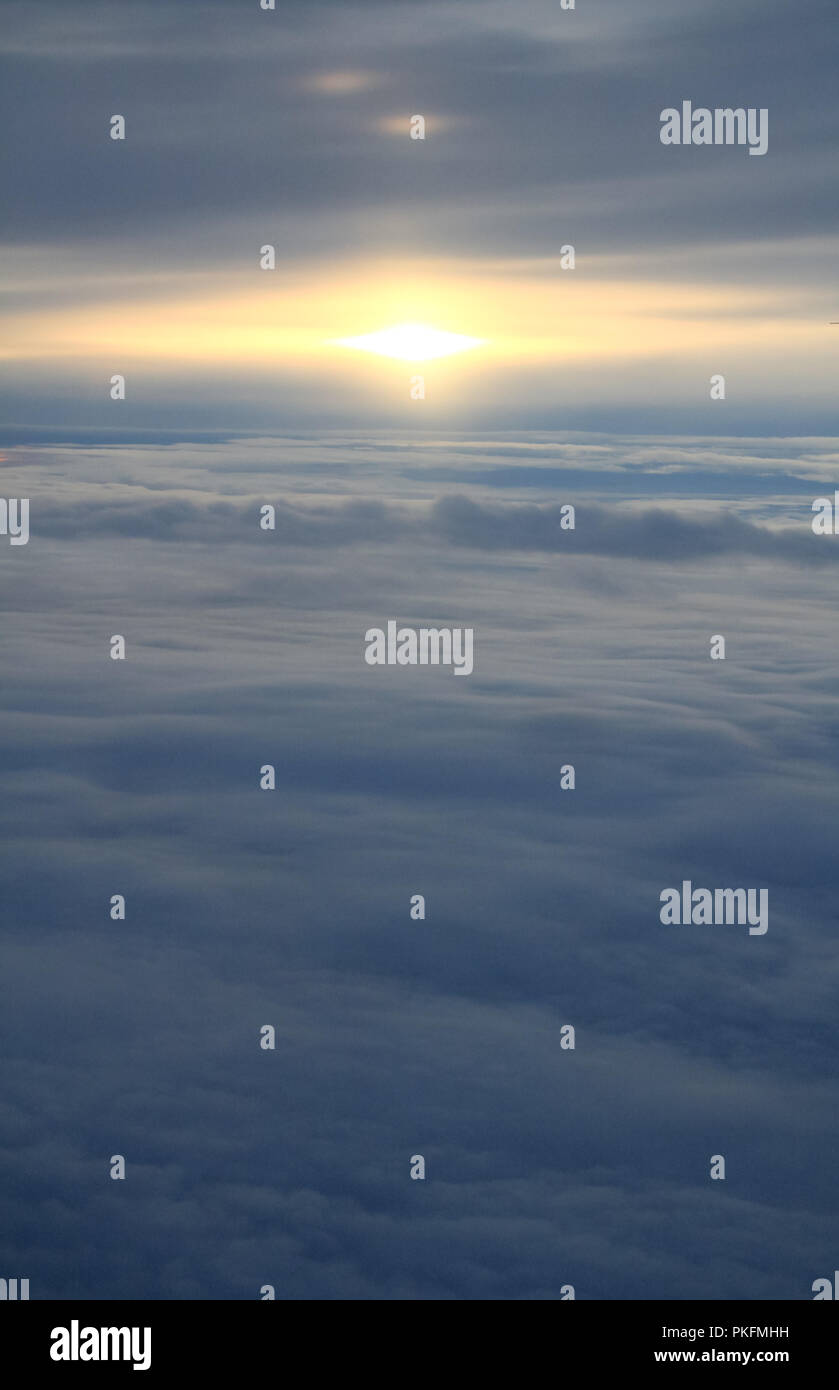 Tramonto sul mare di nubi e la linea di orizzonte da un piano Foto Stock