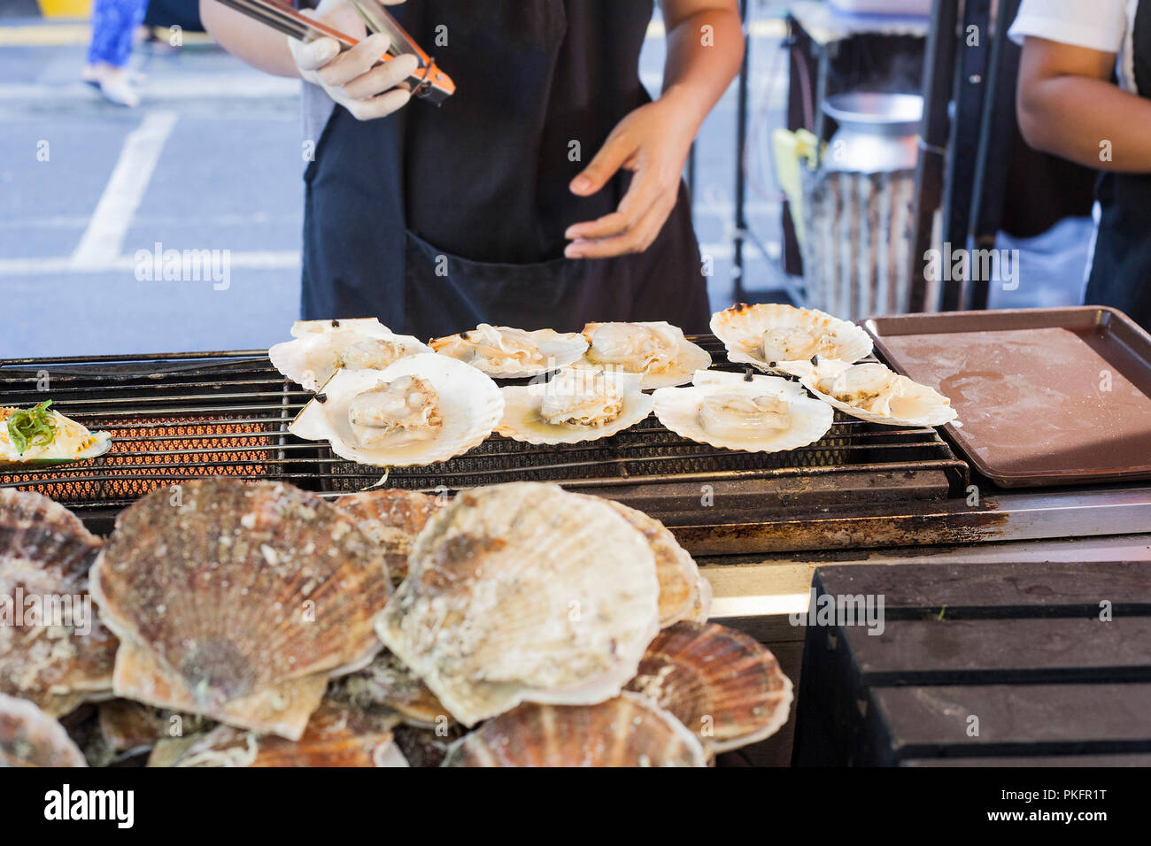 Sano tailandese Sea la cottura del cibo. Grandi Capesante alla griglia su strada del mercato di Phuket, Tailandia Foto Stock