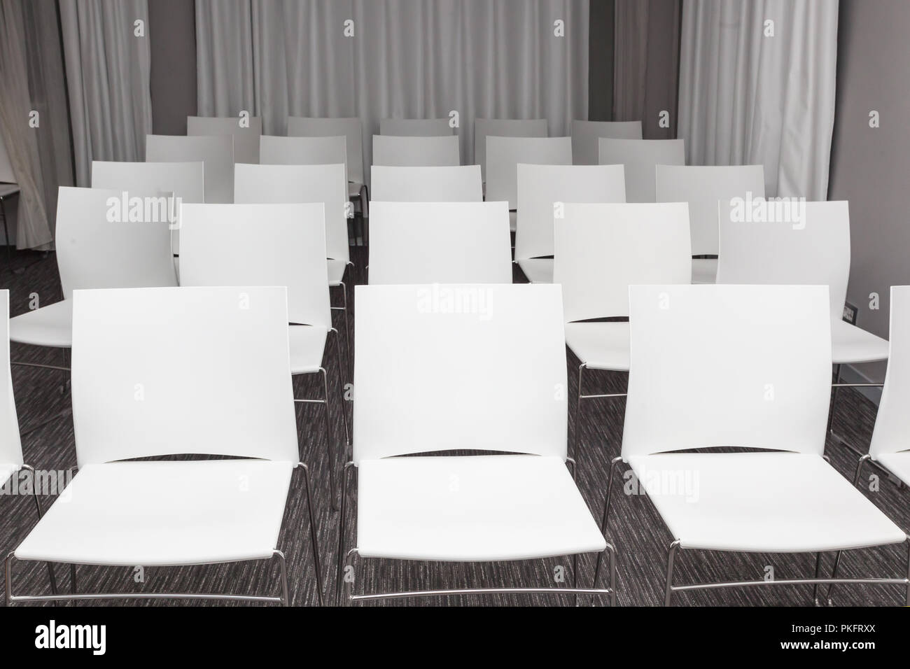 Gruppo di vuoto sedie bianche nella moderna sala conferenze - presentazione sala per seminari Foto Stock