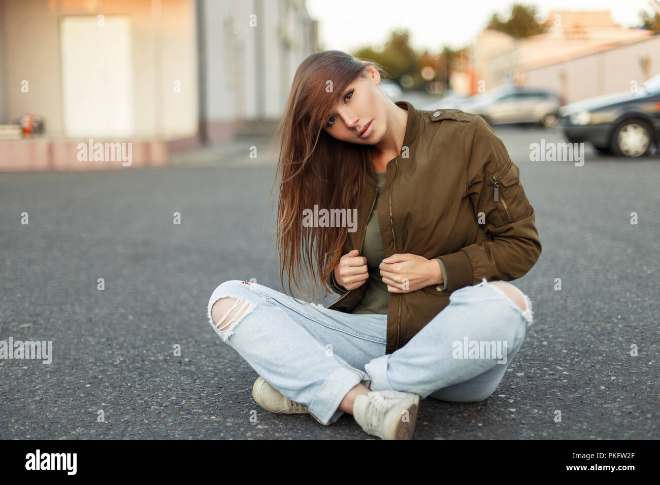 Vogue bella donna in una camicia alla moda e jeans strappati su asfalto  Foto stock - Alamy