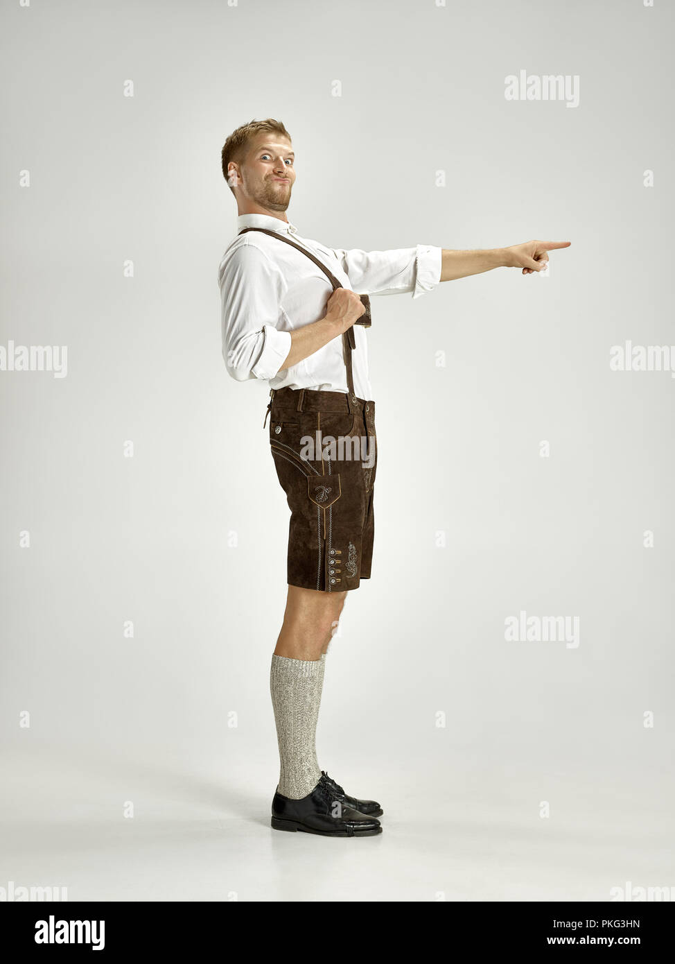 Ritratto di Oktoberfest giovane hat, indossando tradizionali bavaresi vestiti in piedi a tutta lunghezza in studio. La celebrazione, oktoberfest, festival concept Foto Stock
