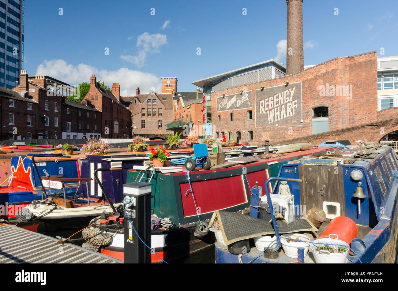 Strette colorate barche ormeggiate in Regency Wharf in Gas Street Basin, Birmingham in bright sole autunnale Foto Stock