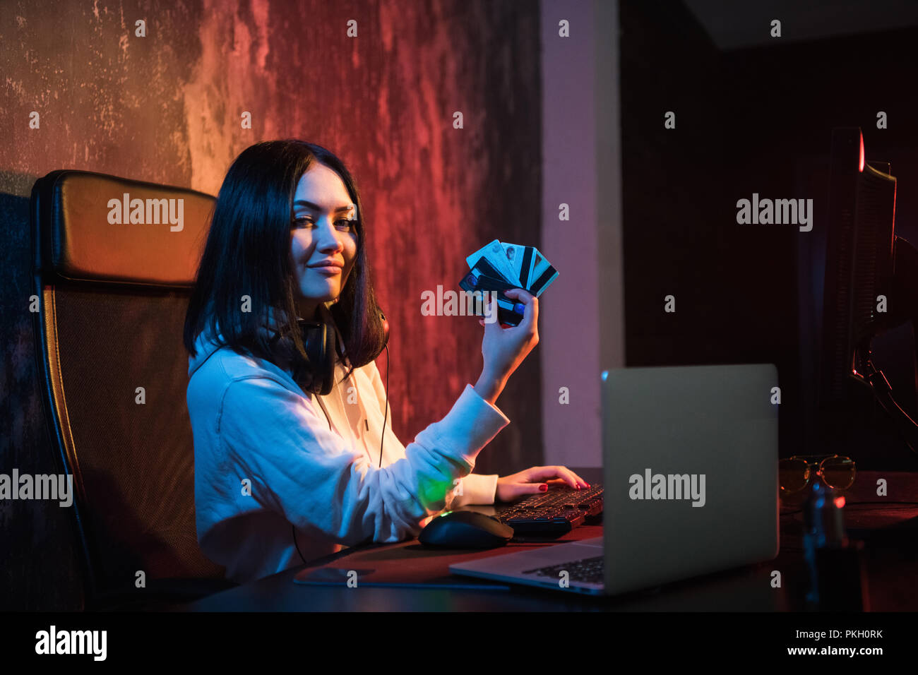 Sorridente gomma giovani in felpa con cappuccio di effettuare acquisti in internet e pagare con carta di credito rubata Foto Stock