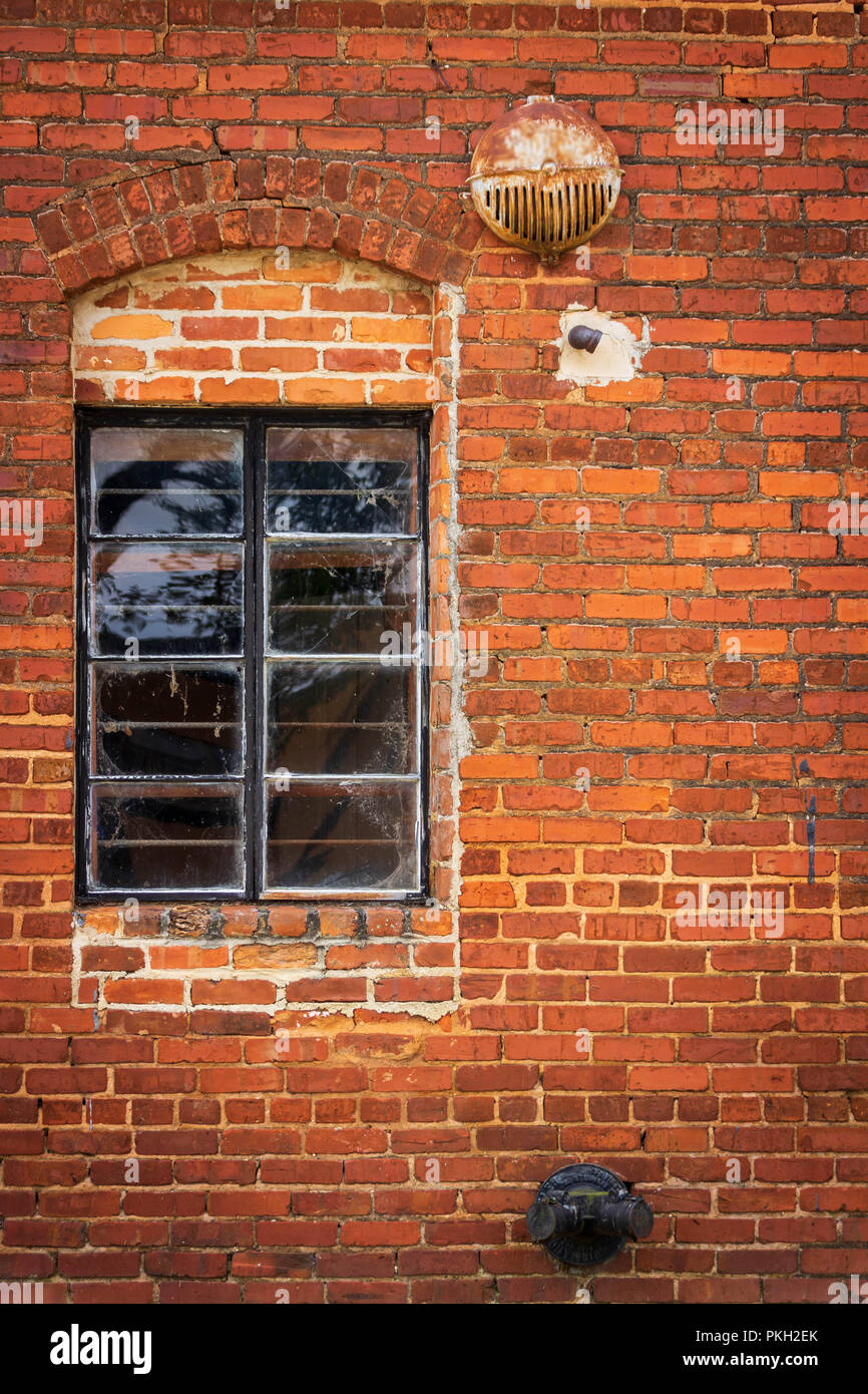 Vecchia finestra su un muro di mattoni e allarme antincendio Foto Stock