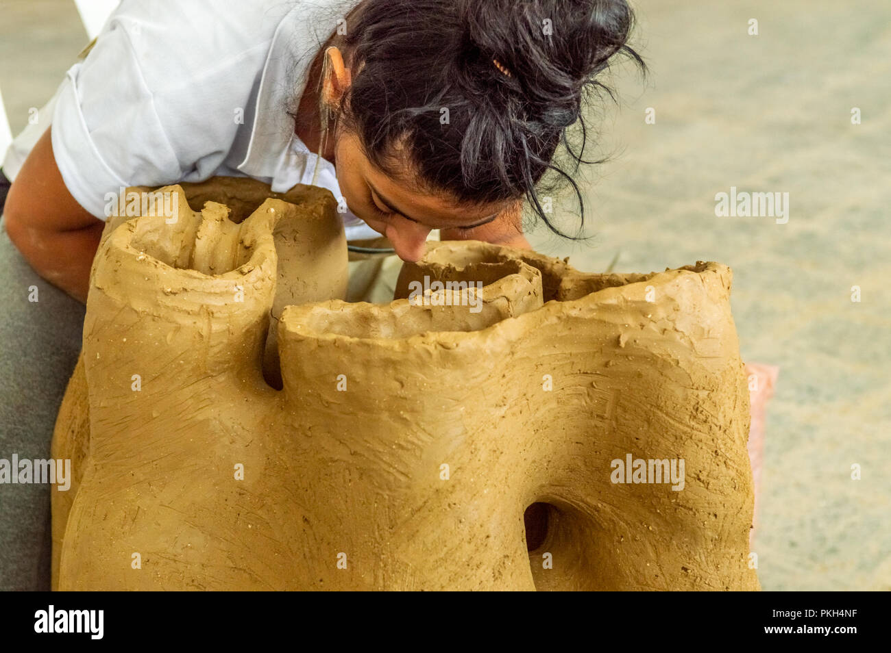 Bella bruna Caucasian artista che lavora per la sua scultura in un atelier Foto Stock