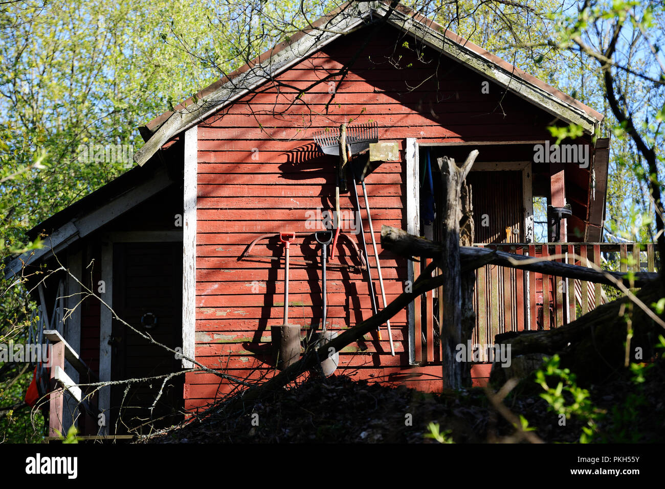 Piccolo giardino rosso tettoia in legno e strumenti Foto Stock