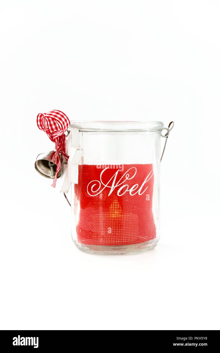 In casa, DIY, il vasetto di vetro Natale lumicino titolare con Noel iscritto, Jingle Bells, nastro rosso e la prua. Accesa Tealight all'interno. Foto Stock