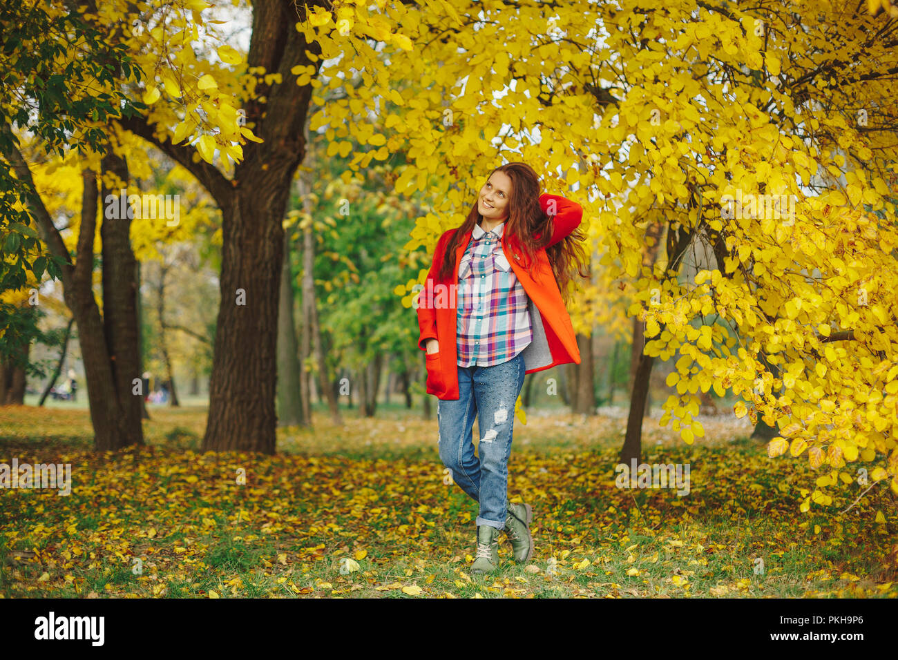 Bella ragazza che gioca con i capelli mentre si cammina nel parco d'autunno. Bella giovane donna di trascorrere del tempo in autunno park. Foto Stock