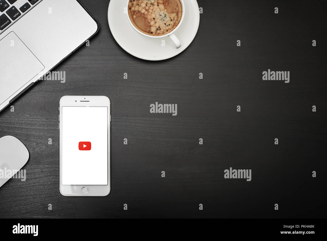 Kiev, Ucraina - Fabruary 6, 2018: Apple iPhone 8 plus con l'app YouTube sullo schermo giacente sulla scrivania nera con cuffie e caffè, vista dall'alto. YouTube Foto Stock