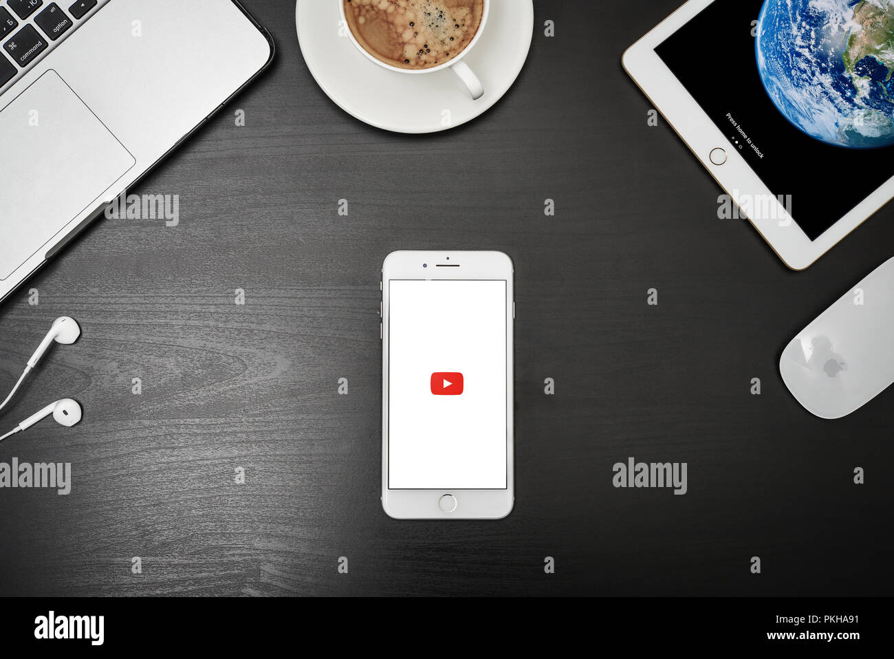 Kiev, Ucraina - Fabruary 6, 2018: Marca nuovo Apple iPhone 8 plus con l'app YouTube sullo schermo giacente sulla scrivania nera con le cuffie, il MacBook Pro e iP Foto Stock