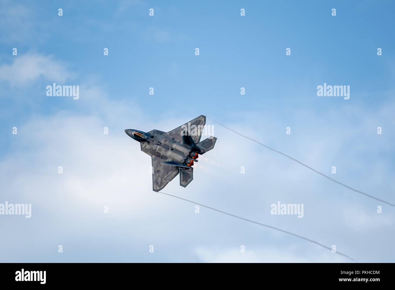 Oshkosh, WI - 28 Luglio 2018: un F-22 battenti con postbruciatore: creazione di contrails in corrispondenza di un'esibizione aerea. Foto Stock