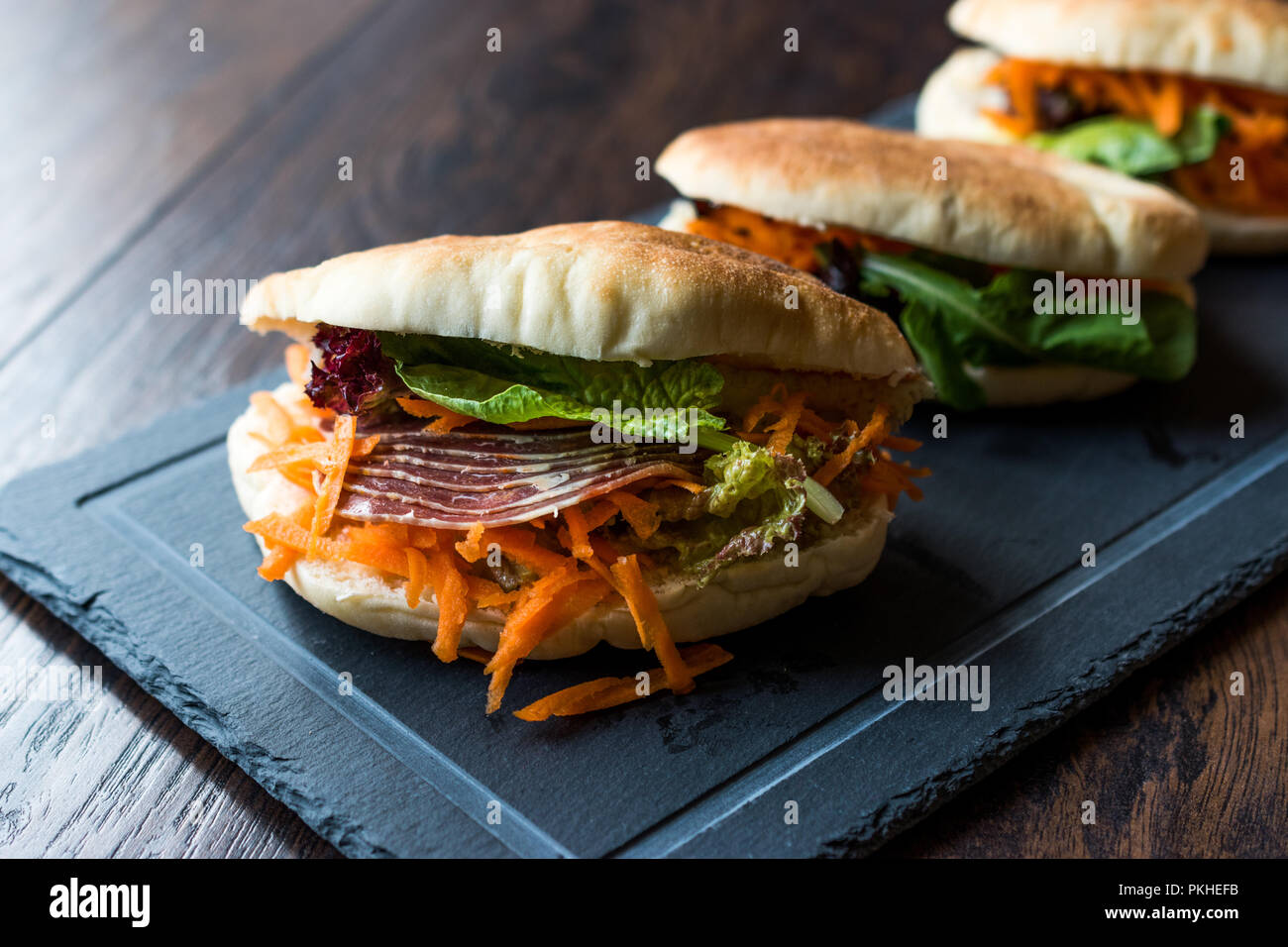 Taiwan ha Pane Pita Bun panino Gua Bao con pancetta affumicata, fette di carota e verde dall'Asia. Tradizionale cibo organico. Foto Stock