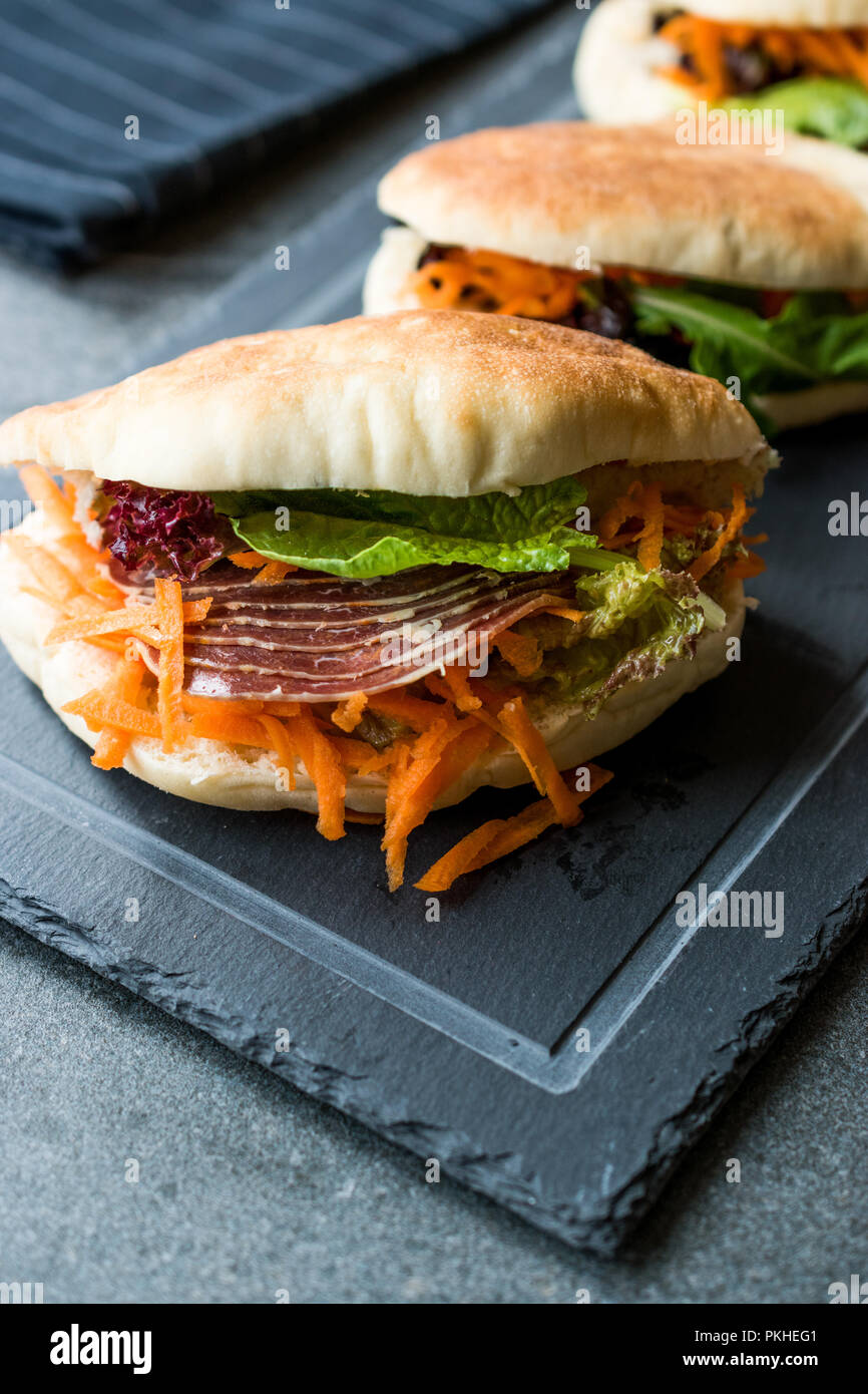 Taiwan ha Pane Pita Bun panino Gua Bao con pancetta affumicata, fette di carota e verde dall'Asia. / Pastrami sandwich pastirma Foto Stock