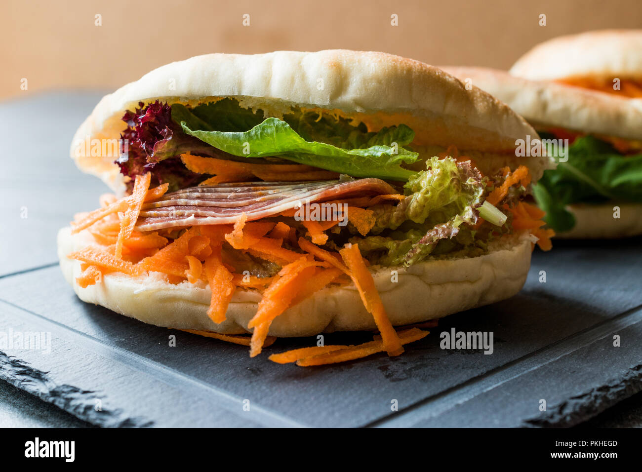 Taiwan ha Pane Pita Bun panino Gua Bao con pancetta affumicata, fette di carota e verde dall'Asia. Pastrami / pastirma Foto Stock