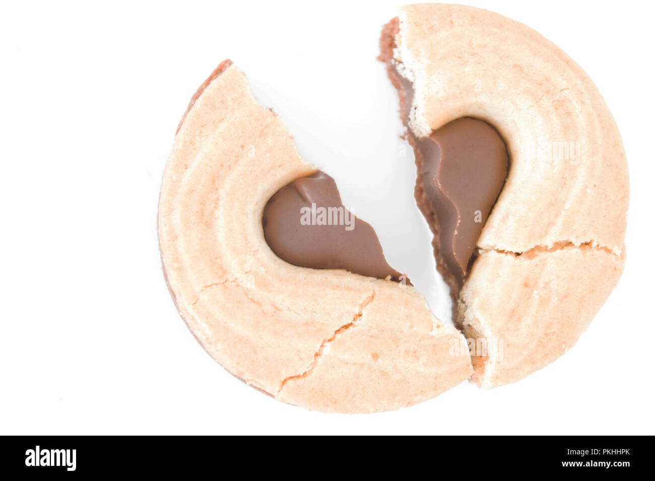 A forma di cuore rotto i cookie su uno sfondo bianco. Concetto di un cuore spezzato. Foto Stock
