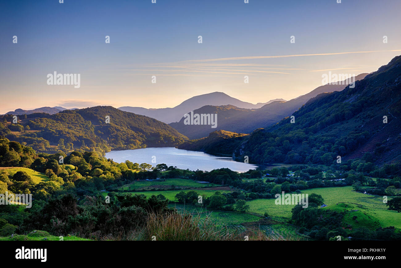 Llyn Gwynant (lago) come il sole tramonta dietro le montagne in Snowdonia (Eryri), il Galles (Cymru), Regno Unito Foto Stock