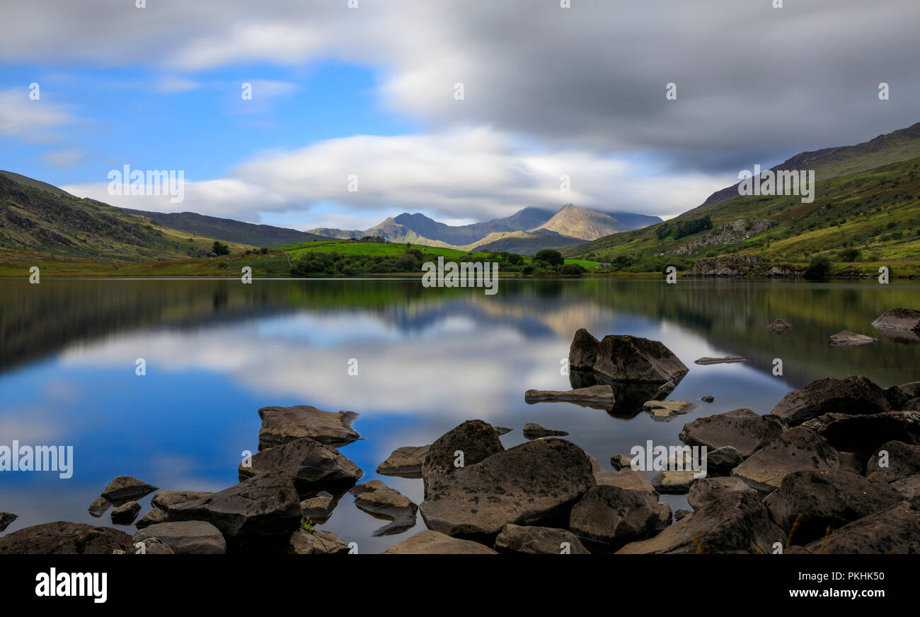 Il vertice di Snowdon con un lavaggio di cloud su di esso. Il lago, Llynnau Mymbyr, riflettendo la scena. Snowdonia (Eryri), il Galles (Cymru), UK. Foto Stock