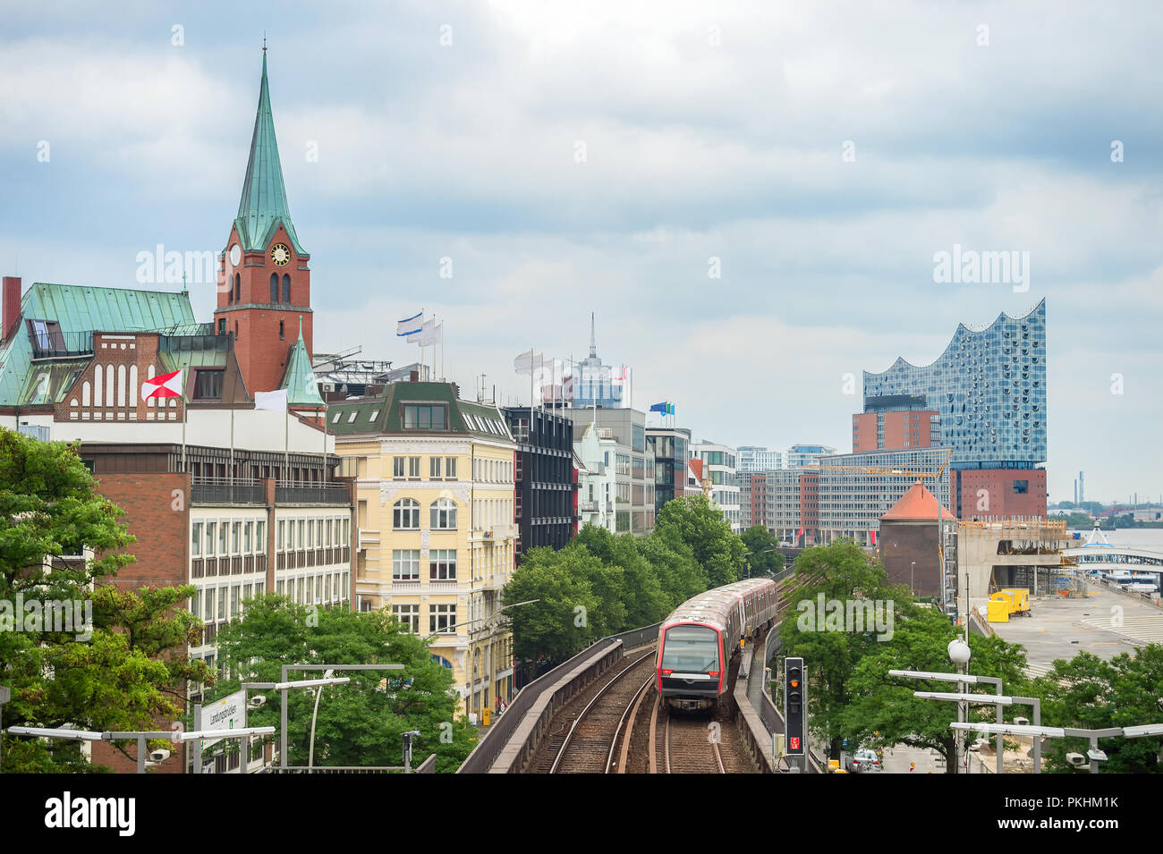 Treno Metro passando dal terrapieno di Amburgo con la torre dell orologio e Elbphilharmonie edificio a sfondo, Germania Foto Stock