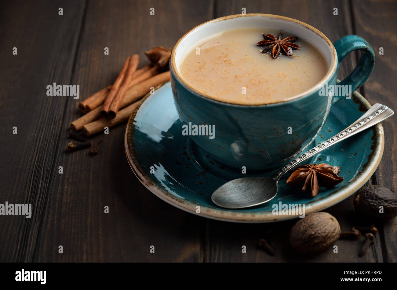 Indian masala chai tea. Il tè speziato con il latte sul legno scuro tavolo. Foto Stock