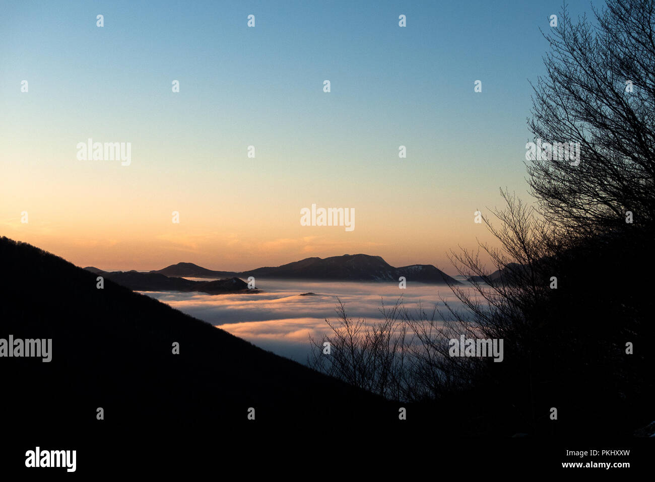 L'Italia, Regione Molise, zona appenninica, 12/24/2012: nebbia e nuvole basse coprono una valle durante il tramonto Foto Stock