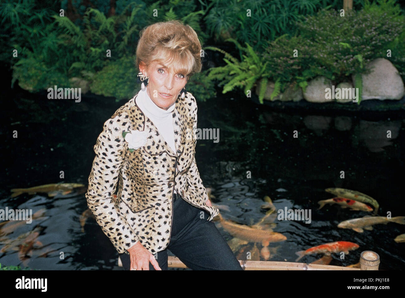 Ehefrau Elisabeth (Lippens) von Fürst Ferdinand von Bismarck posiert vor einem Koi Karpfen Teich im Garten vom Familiensitz der Bismarcks Schloss Friedrichsruh nahe Amburgo, Deutschland 2006. La moglie Elisabeth (Lippens) del principe Ferdinand von Bismarck pone di fronte un carpe koi pond nel giardino della residenza di famiglia di Bismarck Schloss Friedrichsruh vicino ad Amburgo, Germania 2006. Foto Stock