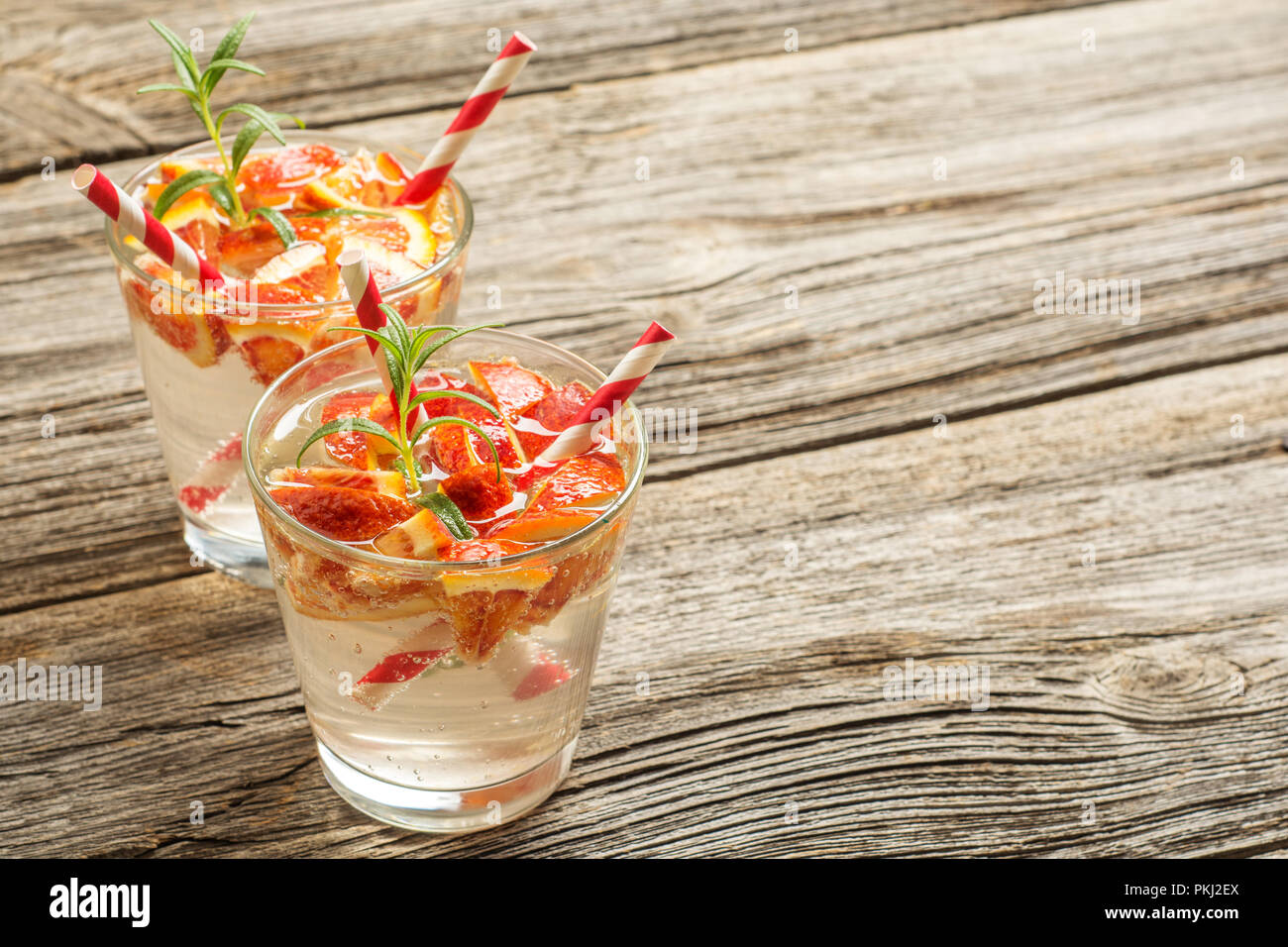 Acqua detox con arancia e rosmarino sul vecchio sfondo di legno come limonata ristoro. spazio per il testo Foto Stock