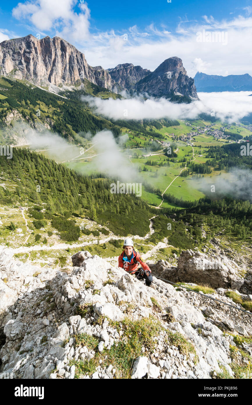 Giovane femmina attraente alpinista su una difficile via ferrata nelle Dolomiti in Alta Badia in Alto Adige in Italia Foto Stock