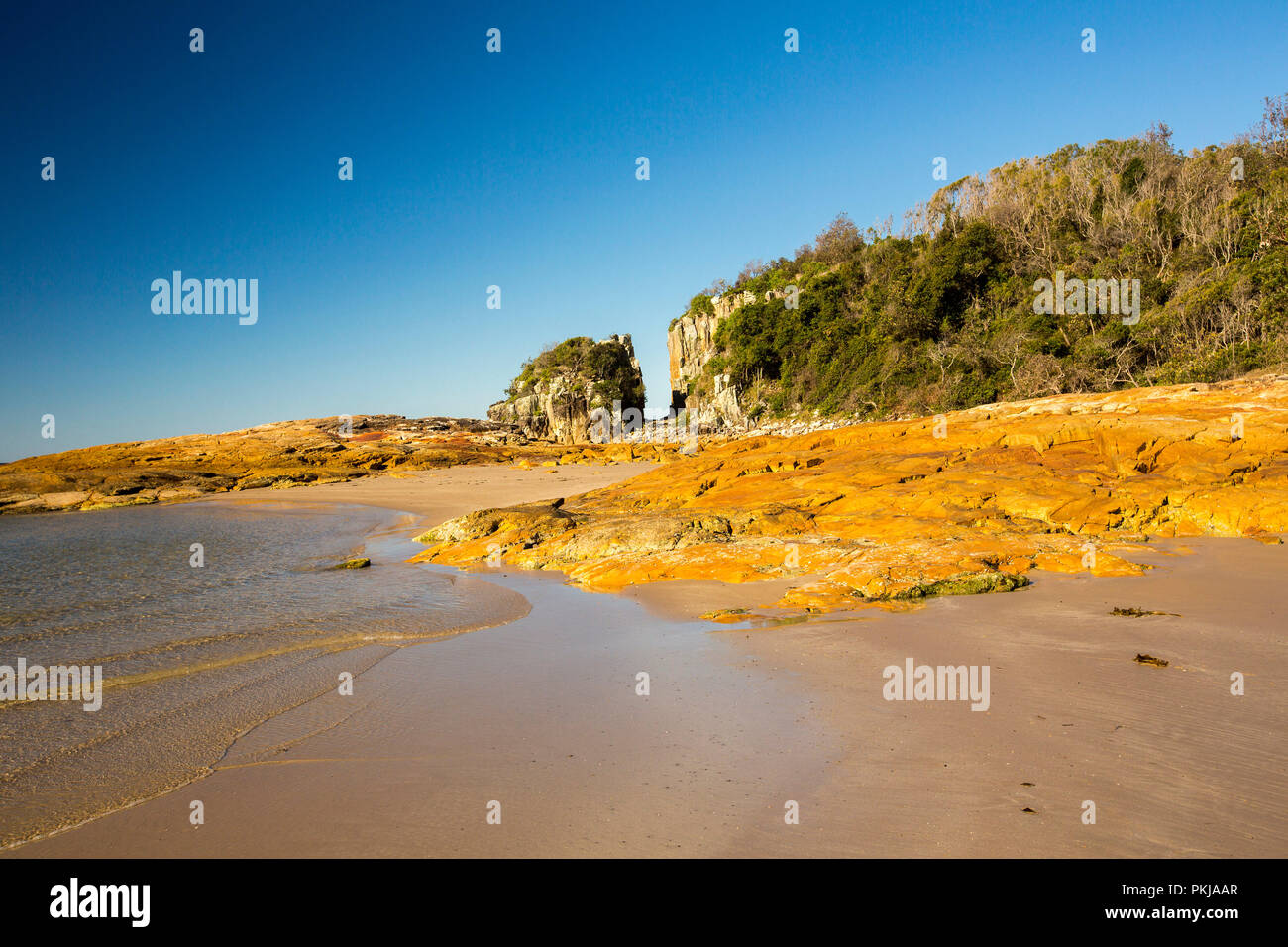 Australian il paesaggio costiero con deserta spiaggia di sabbia e rocce sotto il cielo blu a testa di diamante nella affollata Bay National Park NSW Foto Stock