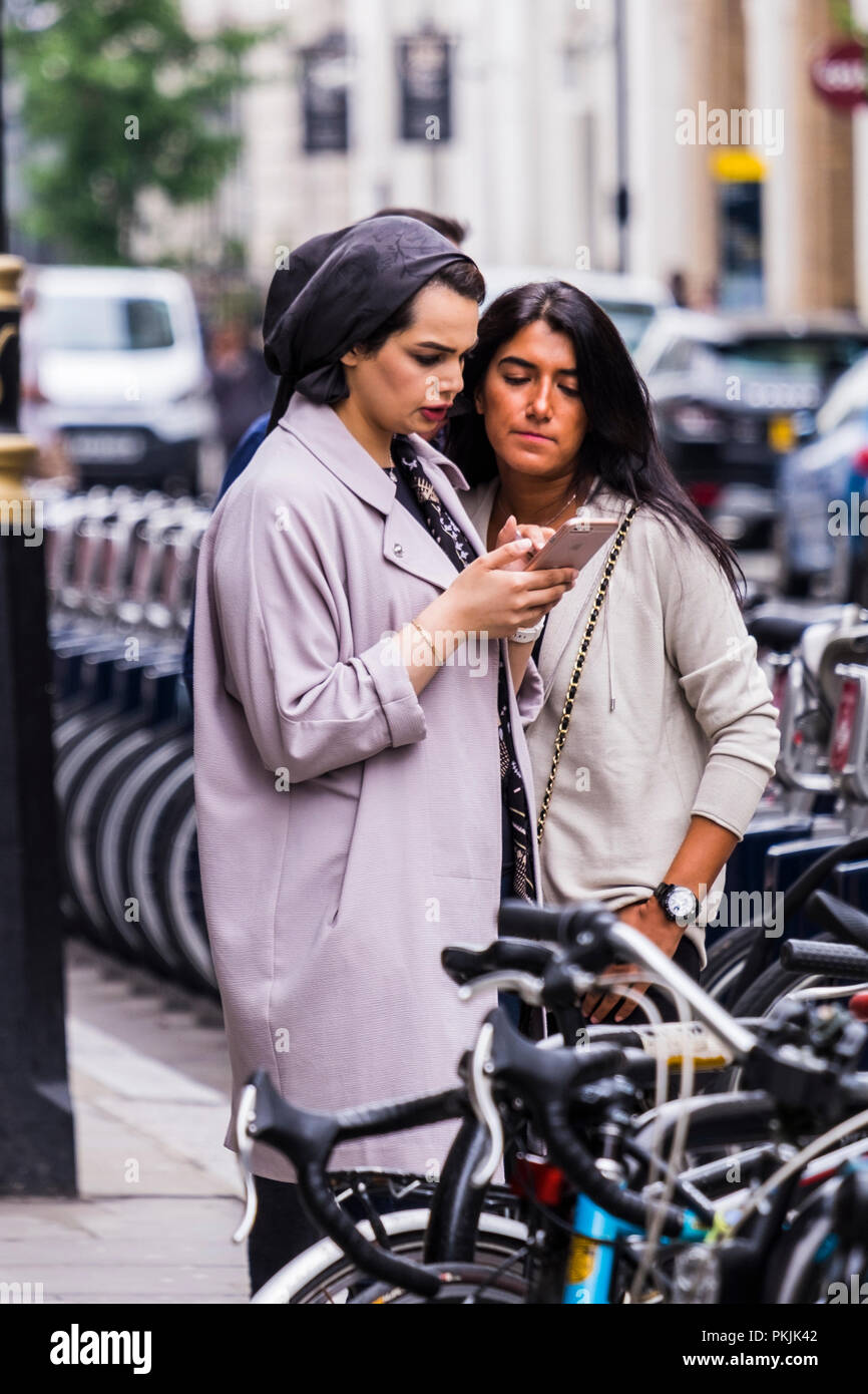 Persone che utilizzano dispositivi mobili fuori strada, City of Westminster, Londra, Inghilterra, Regno Unito Foto Stock