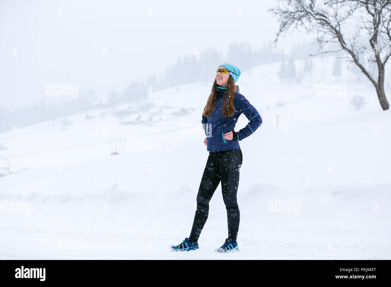 Giovani runner donna in piedi alla strada in inverno Foto Stock