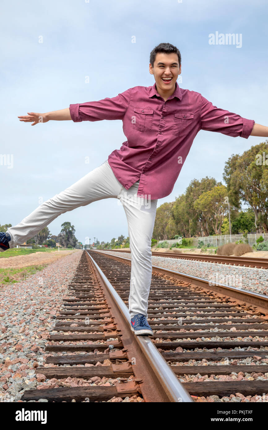 Giovane uomo in equilibrio su traclks ferroviaria in Calsbad, California Foto Stock