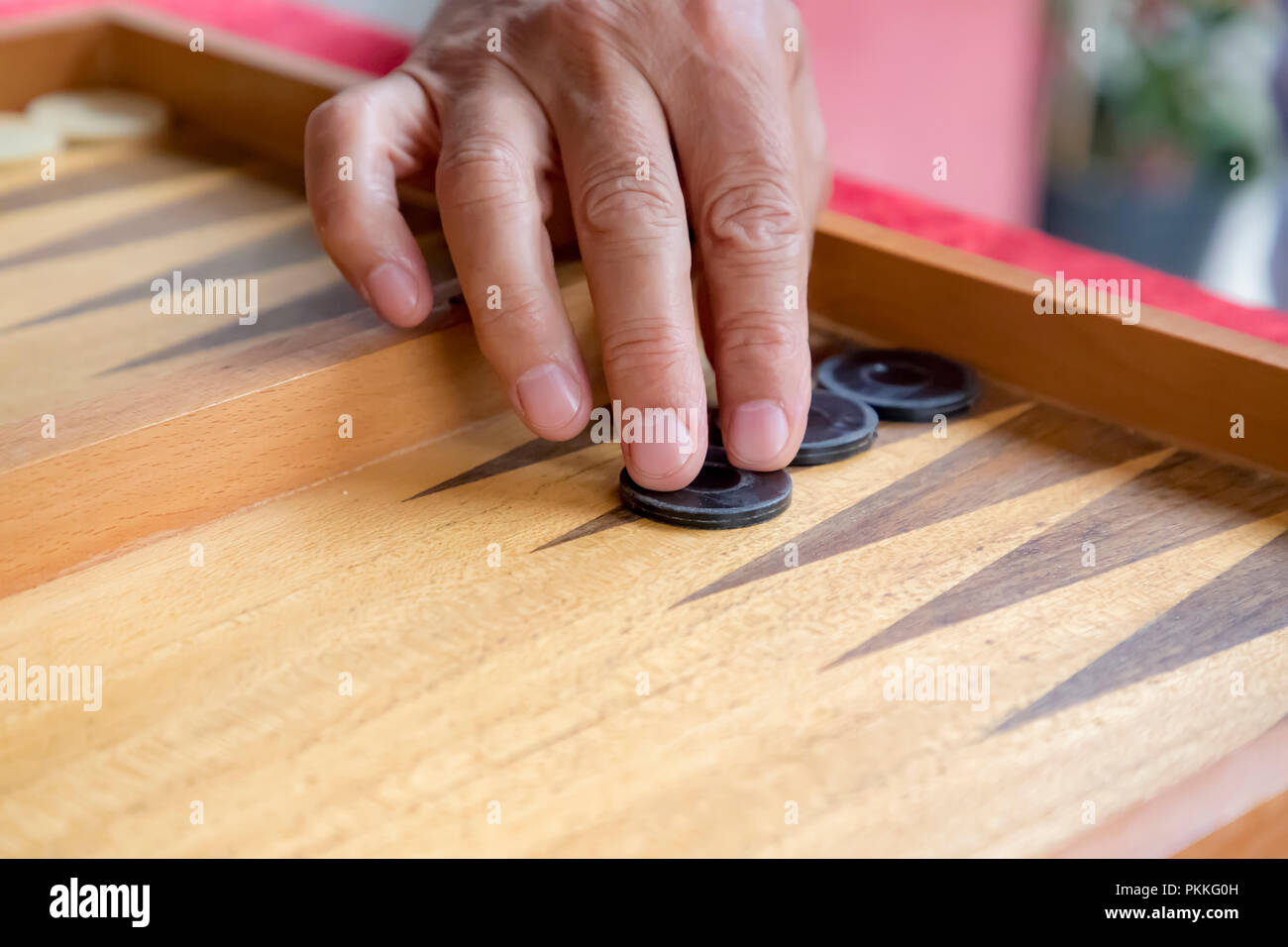 Un uomo si muove di una piscina in un gioco del Backgammon Foto Stock