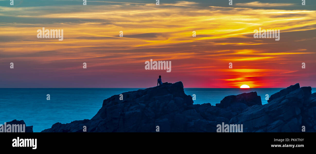 Un prestito figura orologi un glorioso tramonto a Hovs Hallar in Svezia. Foto Stock