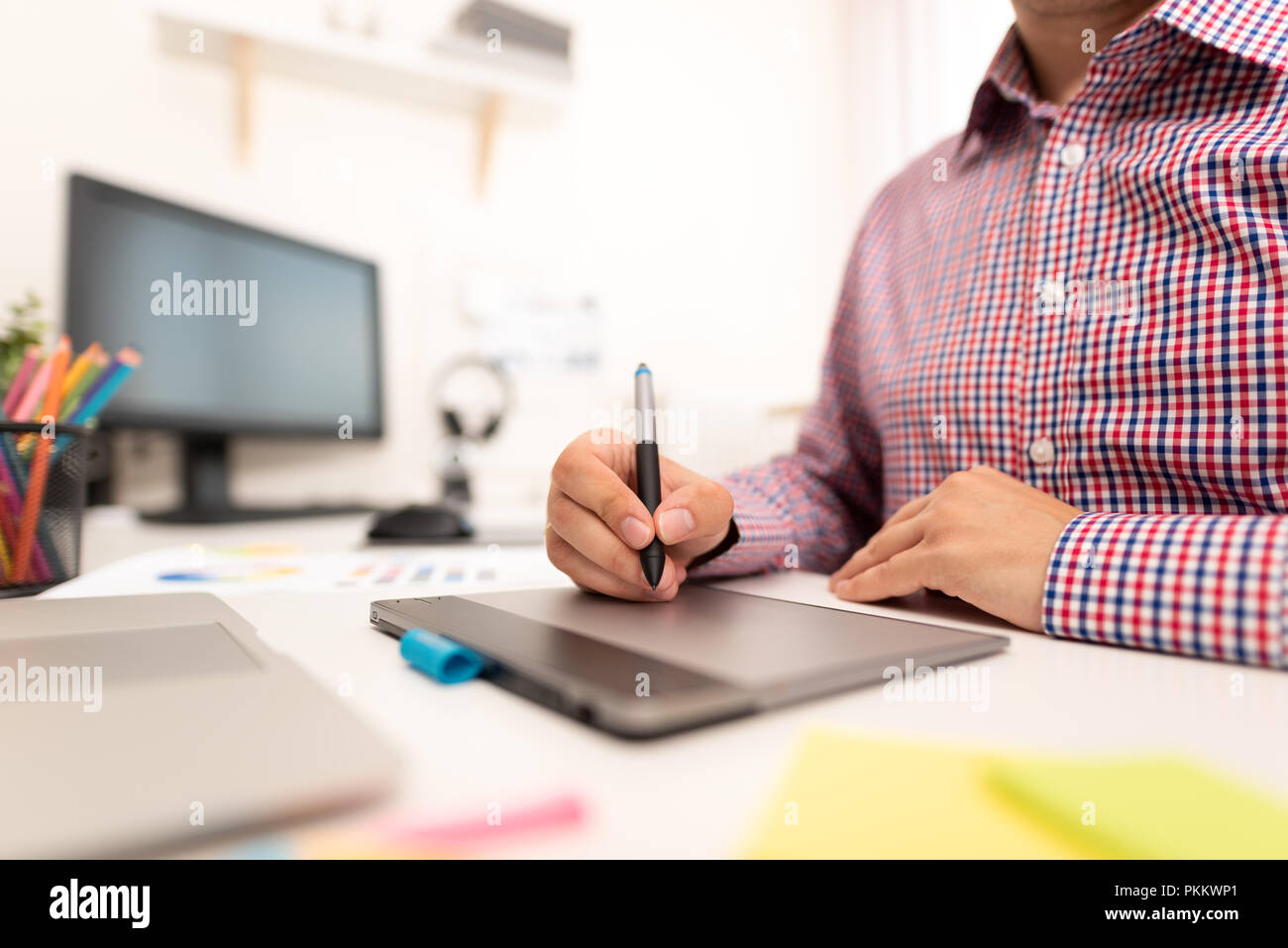 Graphic designer che lavora sulla tavoletta digitale. Il freelance lavoro a casa Foto Stock