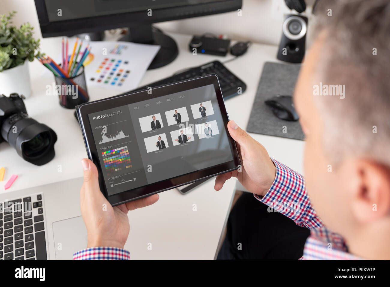 Fotografo guarda le foto sulla tavoletta. Graphic designer al lavoro. Foto Stock
