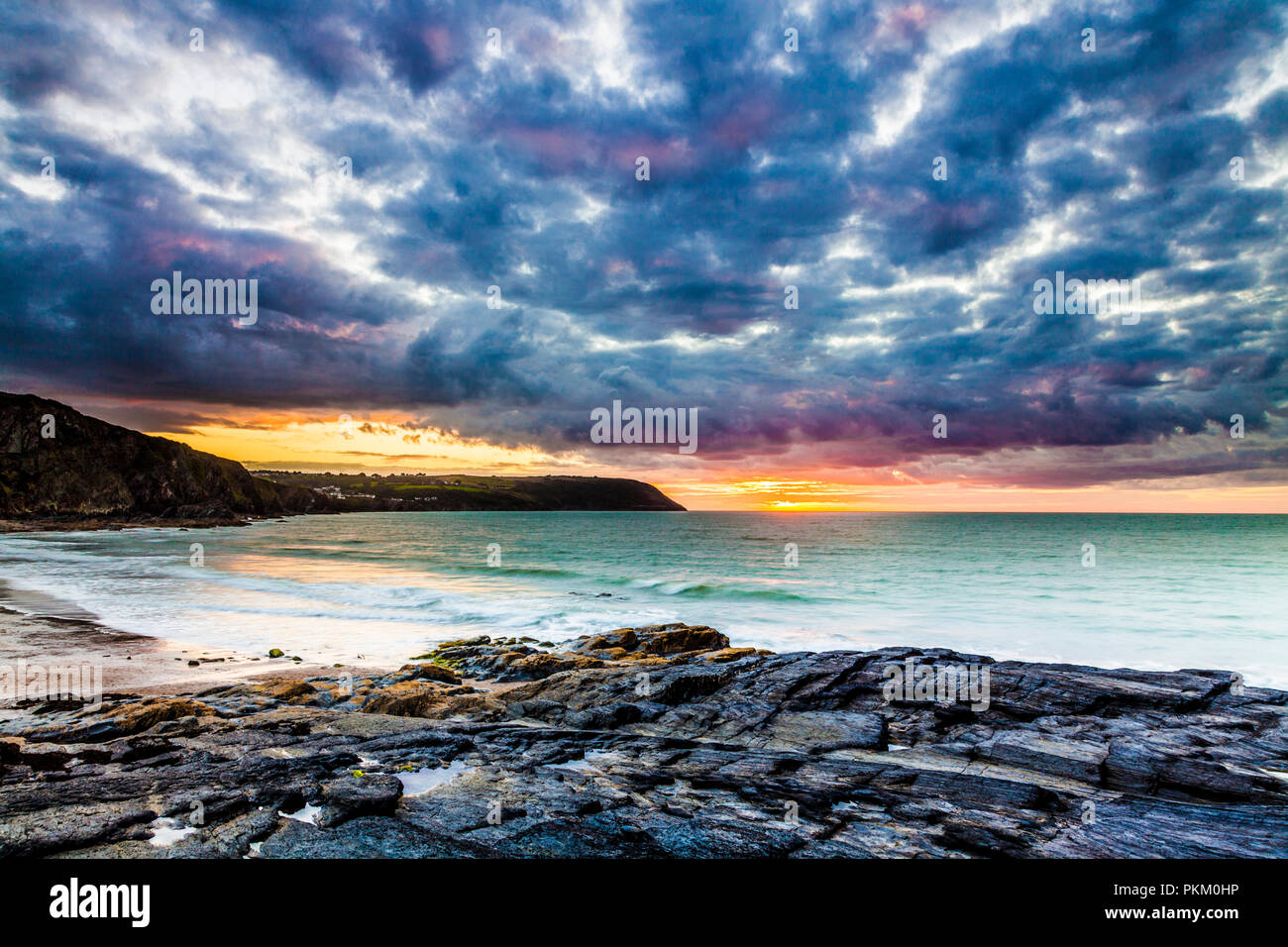 Tramonto sulla spiaggia di Tresaith in Ceredigion, Galles, guardando verso Aberporth. Foto Stock