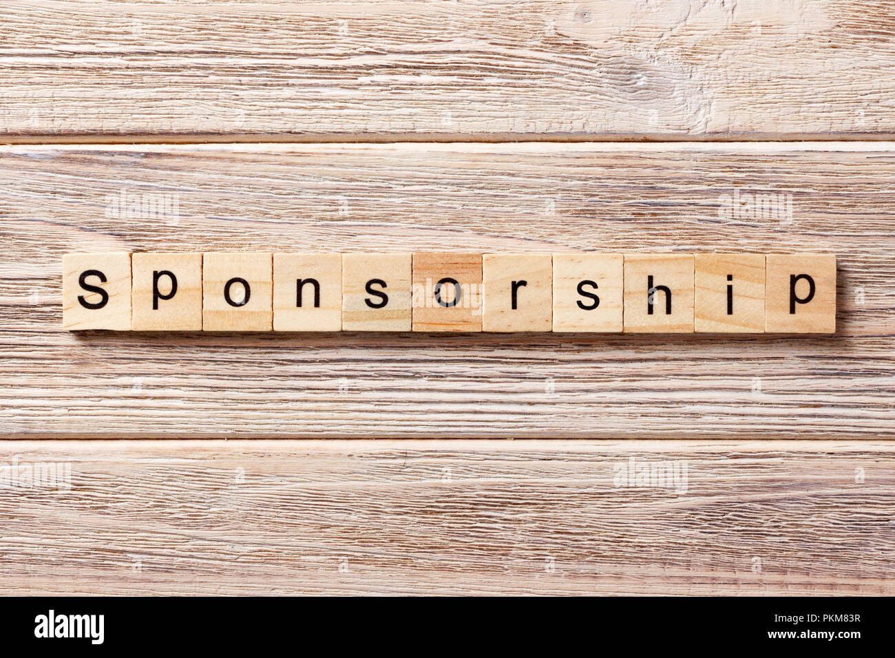 Sponsorizzazione parola scritta sul blocco di legno. La sponsorizzazione del testo in tabella, concetto. Foto Stock