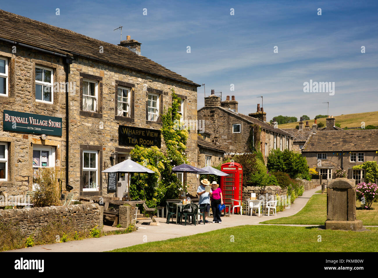 Regno Unito, Yorkshire, Wharfedale, Burnsall, shop, vecchia casella Telefono e sala da tè sul villaggio verde Foto Stock