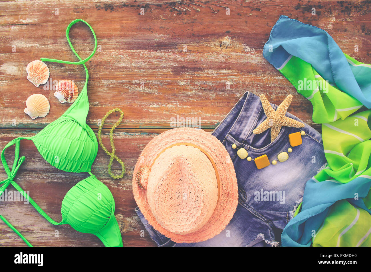 Estate Abbigliamento donna e accessori: hat, costume da bagno e gli shorts in denim, pareo, occhiali da sole, conchiglie. Vista dall'alto. Foto Stock