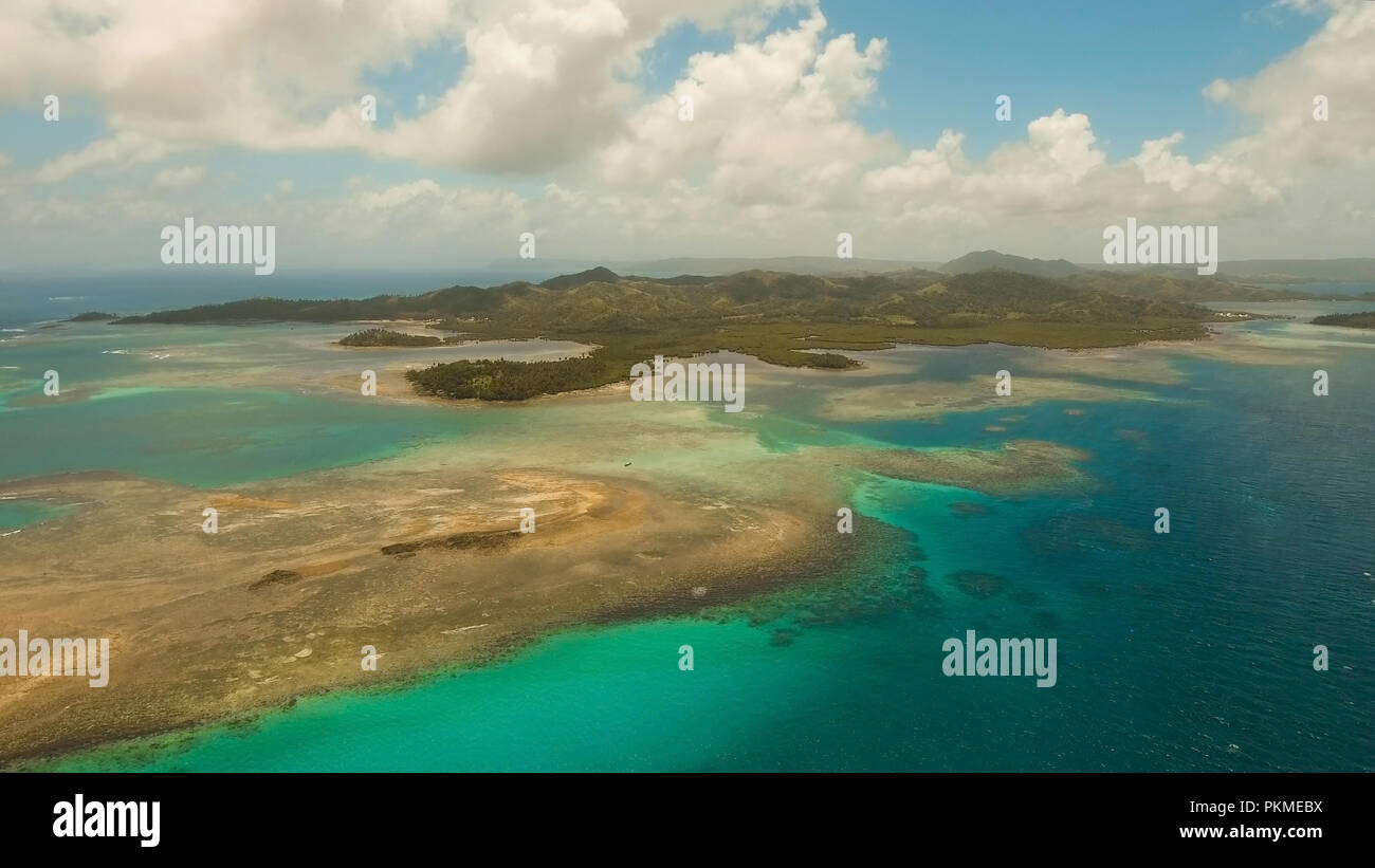 Vista aerea: spiaggia, isola tropicale, Baia Mare e laguna, Siargao. Paesaggio tropicale hill, nuvole e montagne rocce con la foresta pluviale. Acque azzurre della laguna. Paesaggio Shore Bay. Video dell'antenna.Seascape. Foto Stock